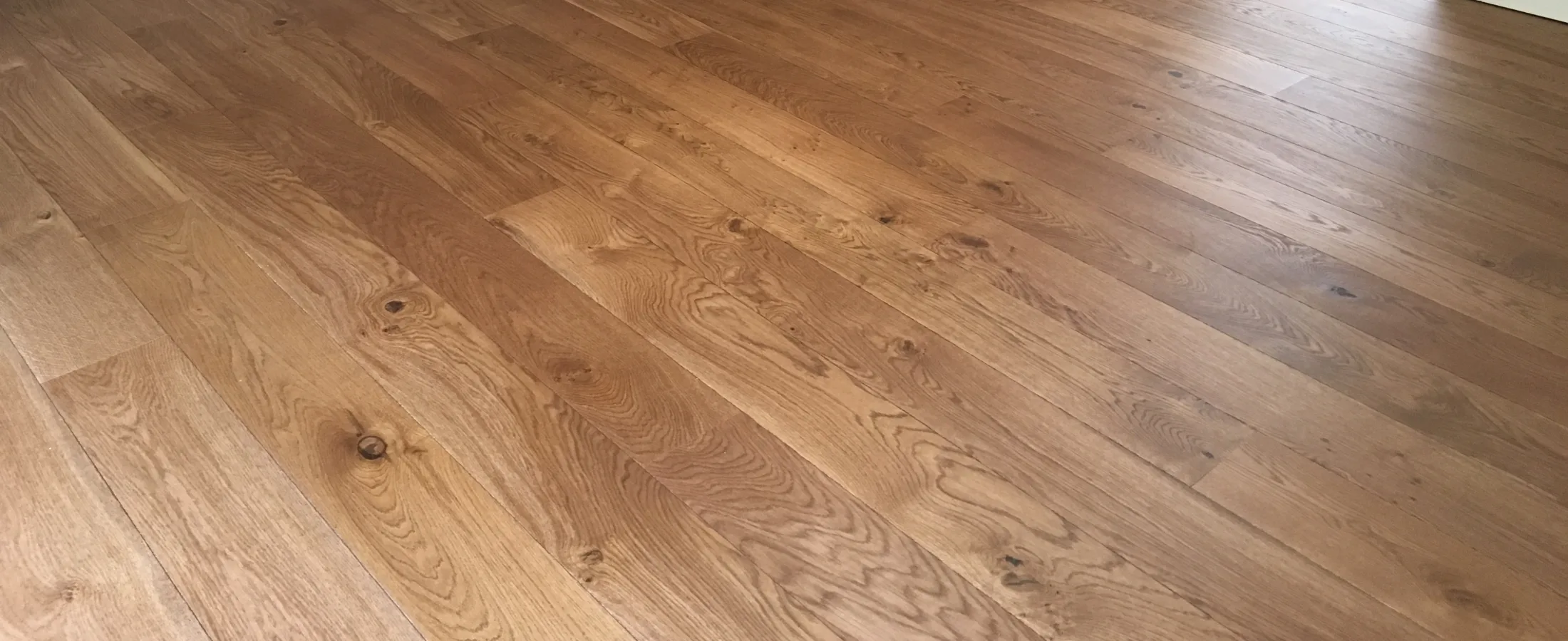 Wide plank engineered oak flooring running through an open-plan room