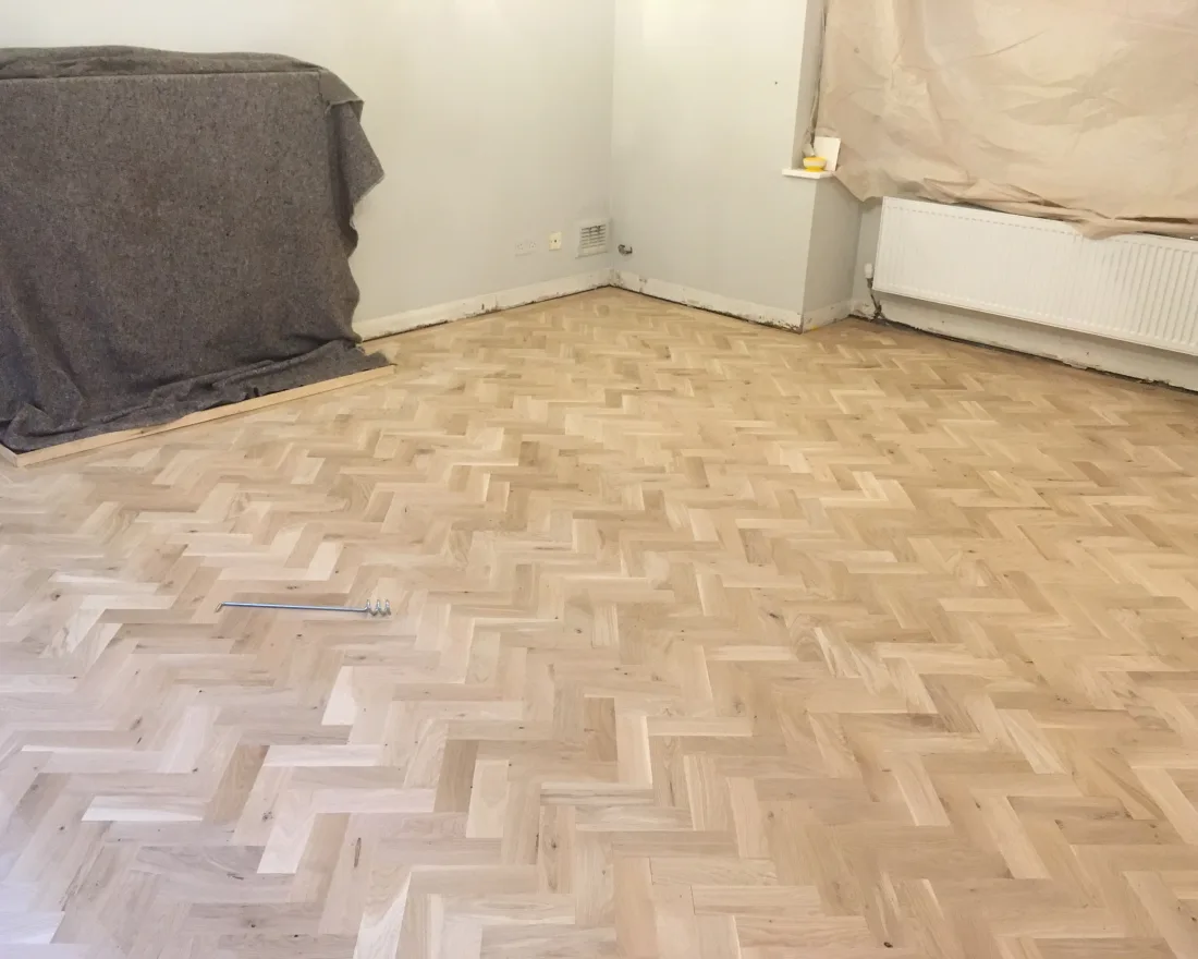 A restored parquet floor catching the light after sanding