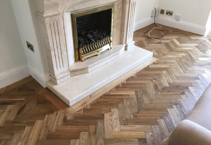 Parquet laid around a stone fireplace