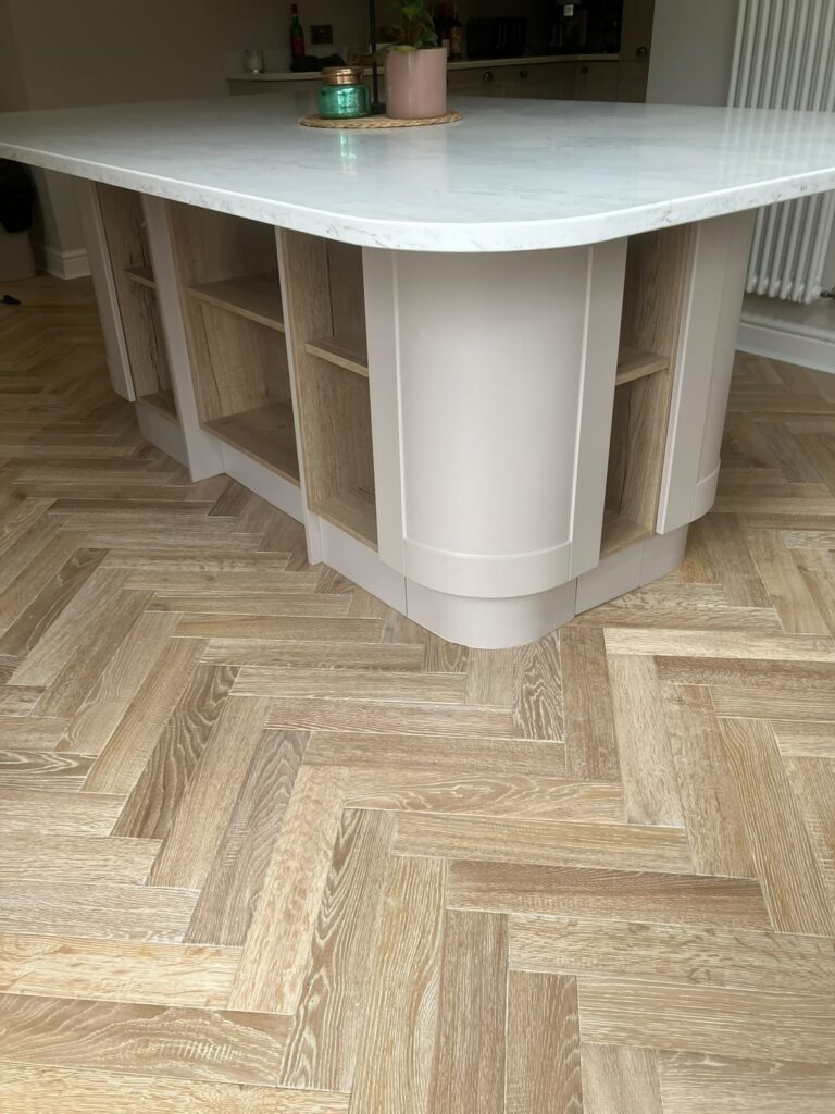 Light oak herringbone floor around a curved kitchen island